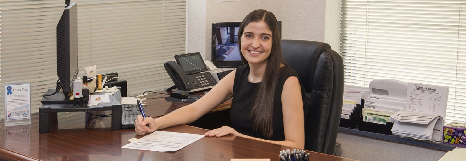 Mortgage Loan Officer working at desk in branch and smiling