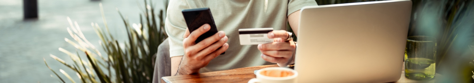 close-up of hands using a smartphone and holding a credit card