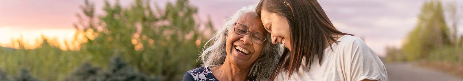 Grandmother and granddaughter laughing while on a walk together