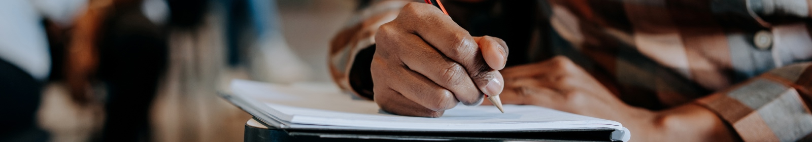 close-up of hands writing in a notebook